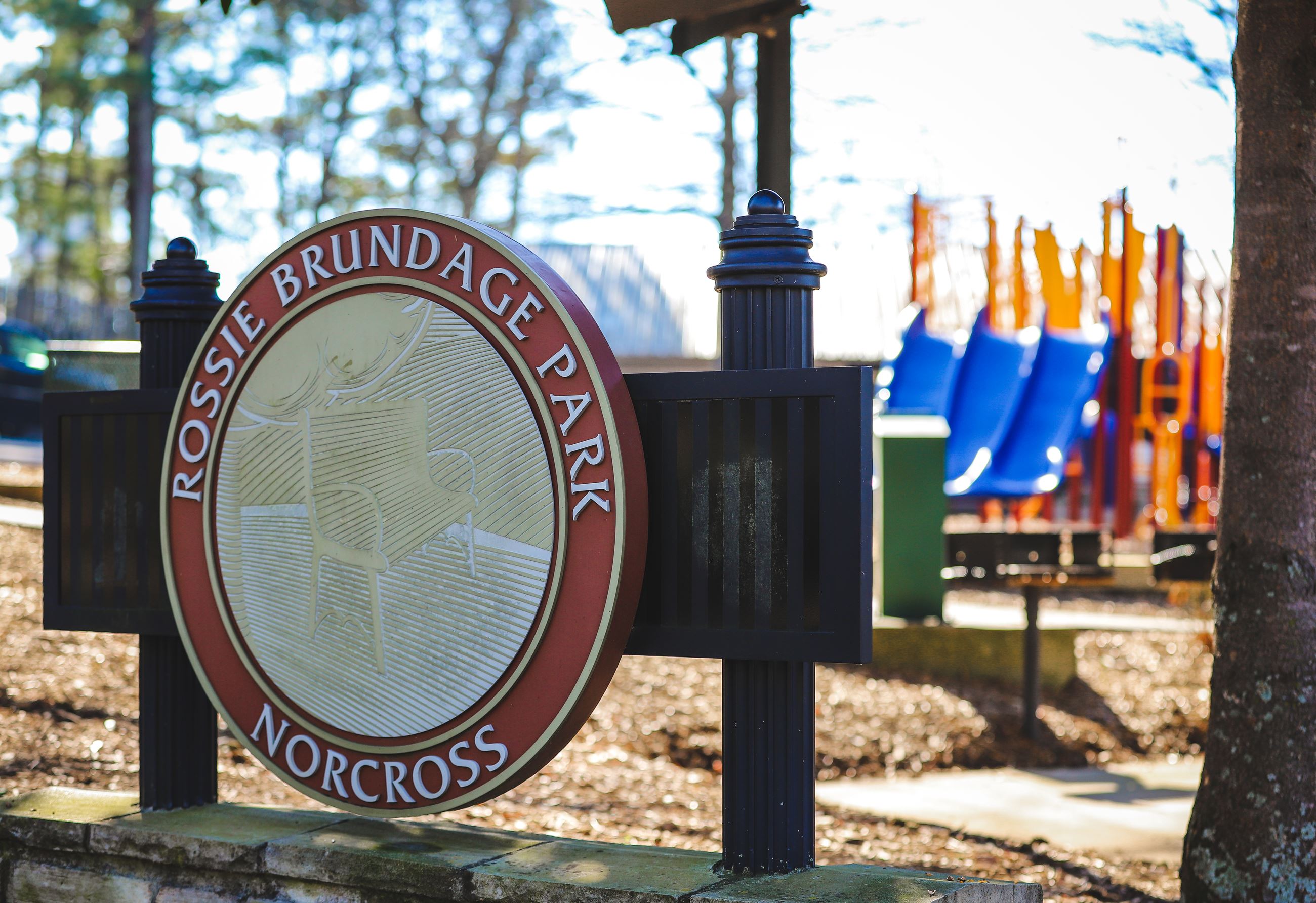 Rossie Brundage Park sign marker with playground in background