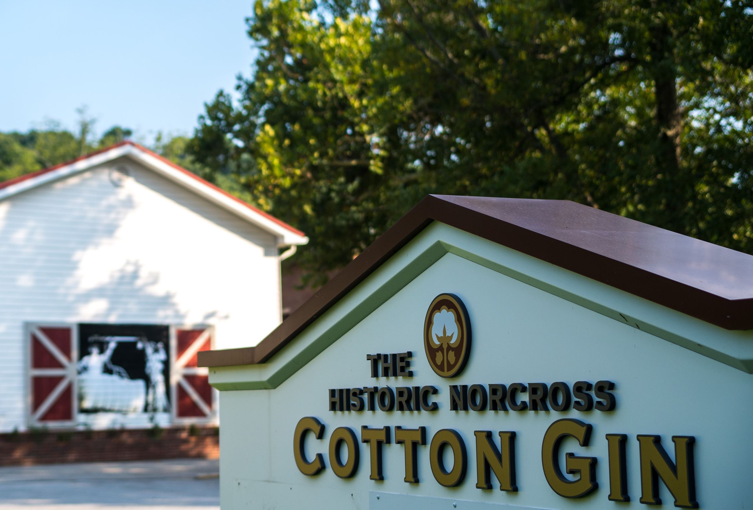 historic cotton gin building with mural and sign