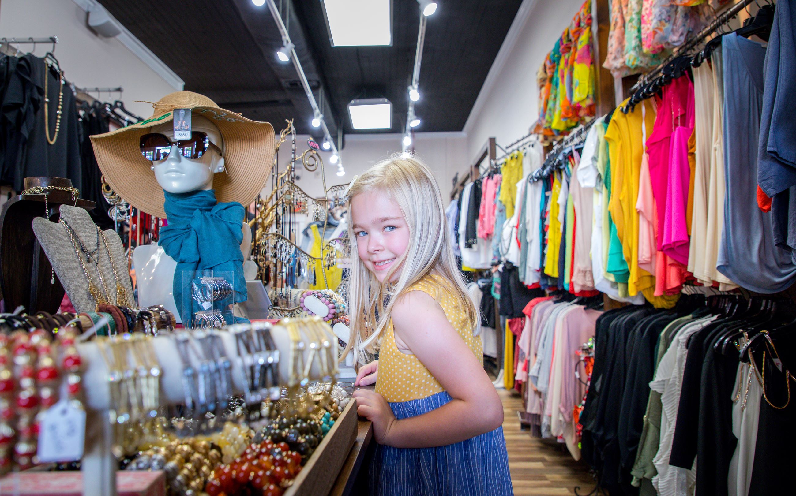 young girl in clothing and jewelry boutique