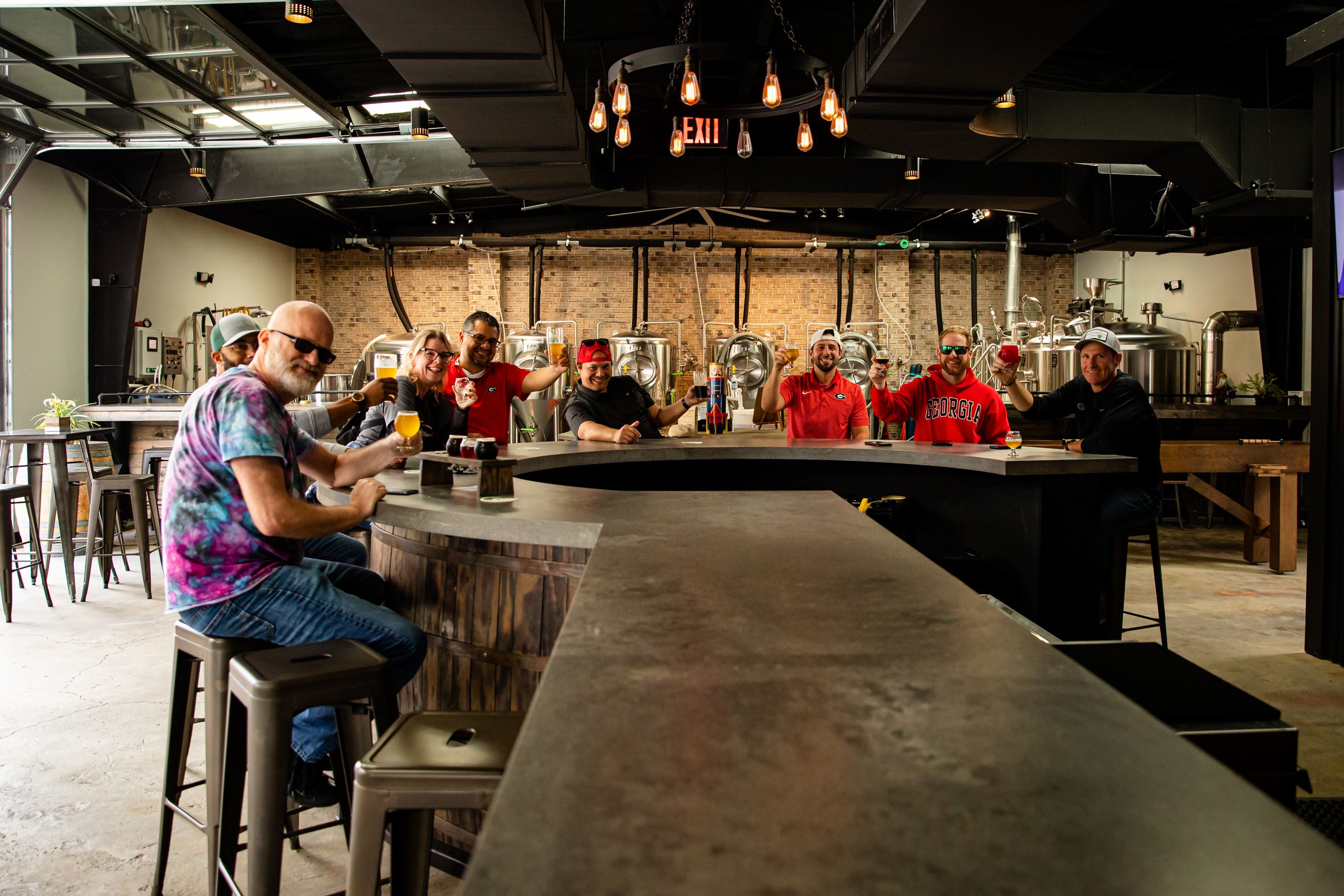 friends toast beer at bar in brewery