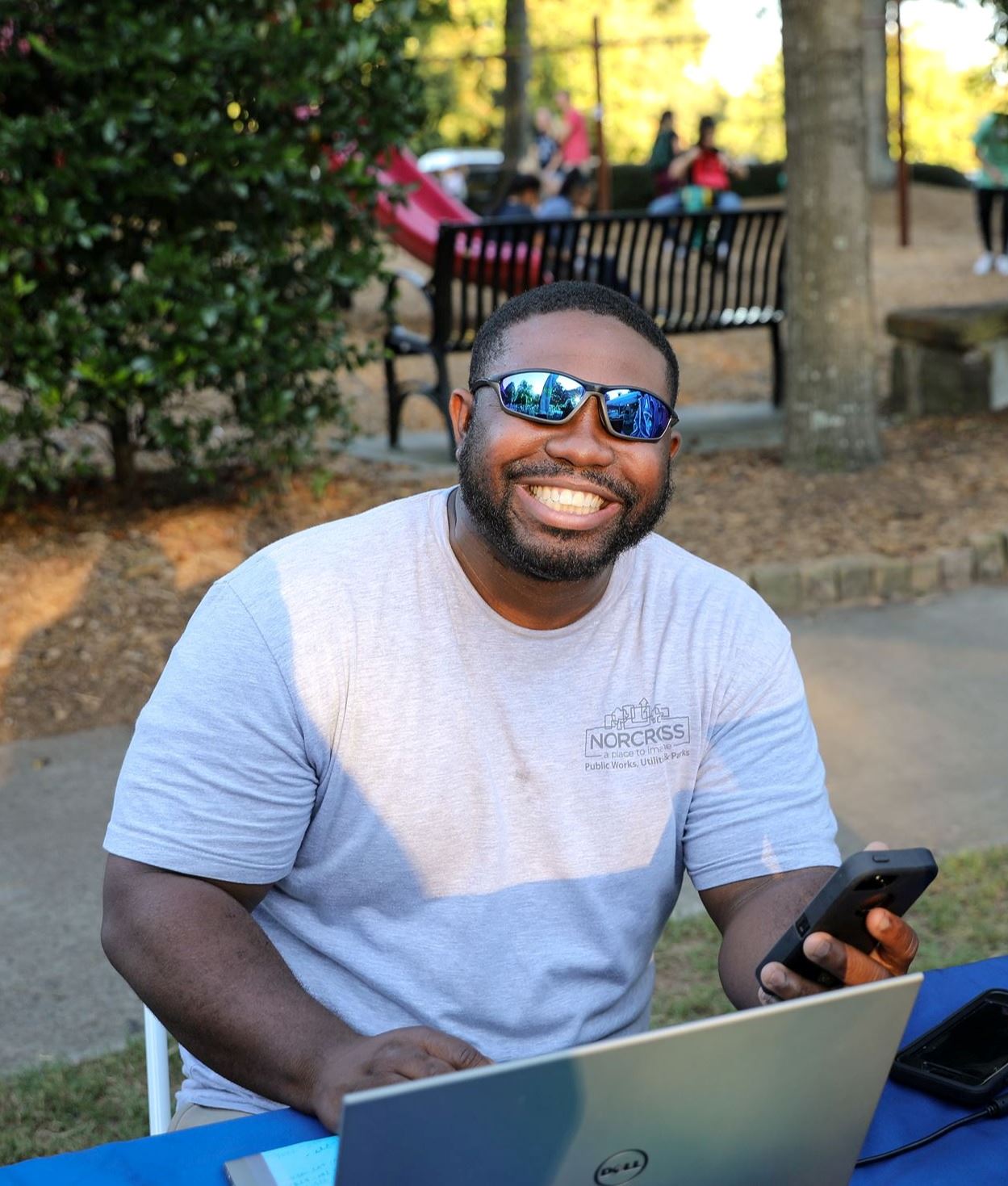 man in sunglasses on phone and computer outside