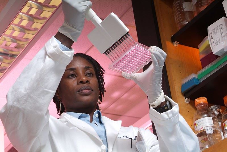 scientist at emory in lab coat looks at culture samples