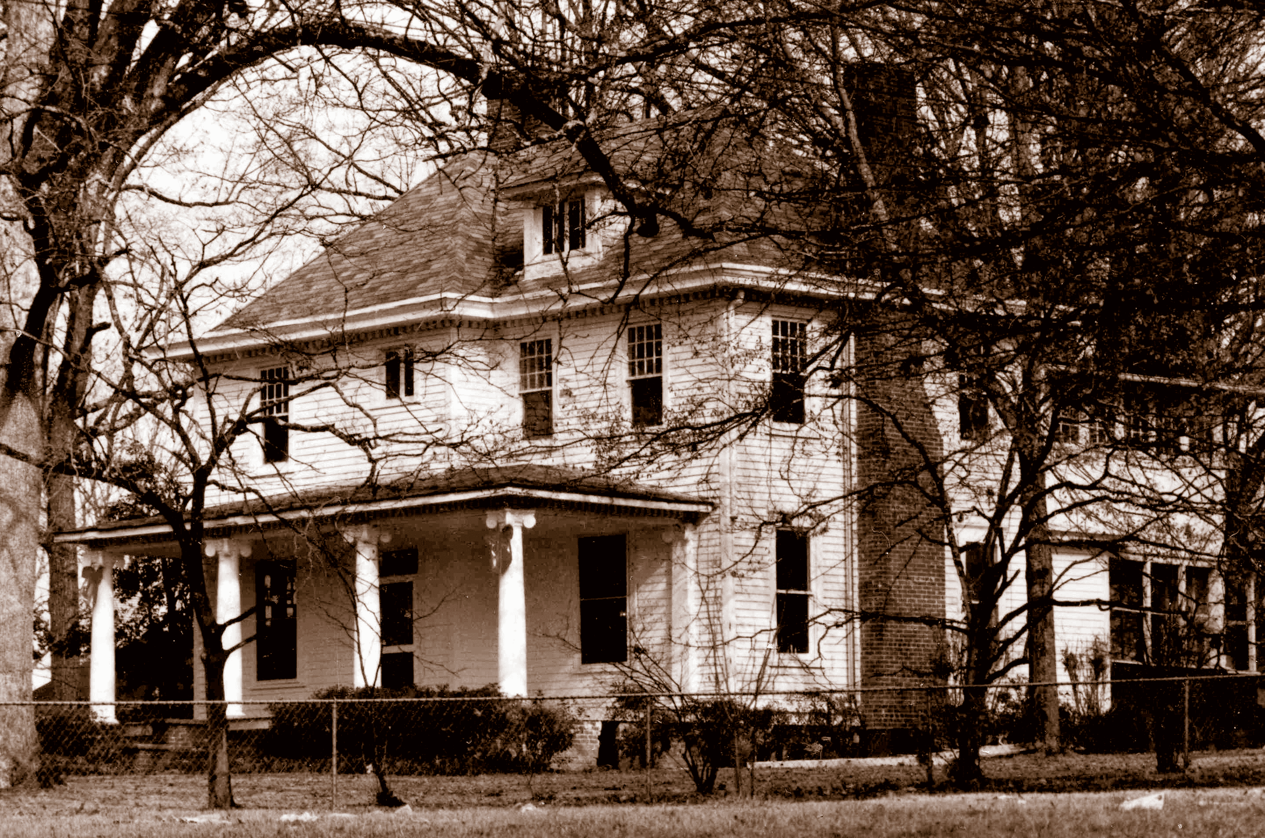 black and white photo of historic two story white house with white columns